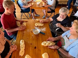 elders and children braiding bread together